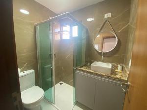 a bathroom with a shower and a toilet and a mirror at Apartamento em Barra do Cunhaú in Barra do Cunhau