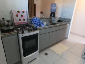 a kitchen with a stove top oven next to a sink at Apartamento em Barra do Cunhaú in Barra do Cunhau