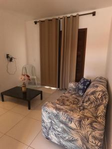 Apartamento em Barra do Cunhaú في بارا دو كونهاو: غرفة معيشة مع أريكة وطاولة