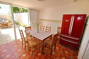 プラヤ・デ・ラス・アメリカスにあるParque Santiago 1 Villa114 Tenerife Rental and Salesのキッチン(テーブル、赤い冷蔵庫付)