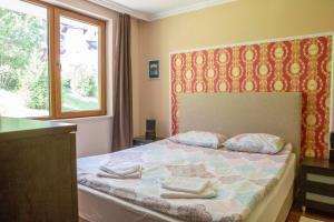 パンポロボにあるApartments in Complex Grand Manastiraのベッドルーム1室(ベッド1台、タオル2枚付)