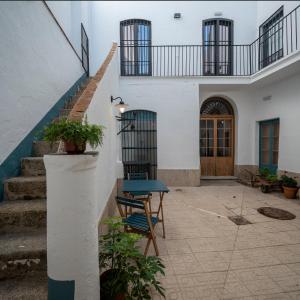 een patio met een trap en een blauwe tafel voor een gebouw bij PETRONILA 1881 in Merida