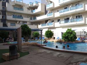 a hotel swimming pool in front of a building at Sea View 2-Bed Apartment - 9 Night Max Stay in Cabo Roig