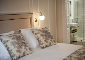 a bed with two pillows and a lamp on it at Apartamentos Petronila 1881 in Mérida
