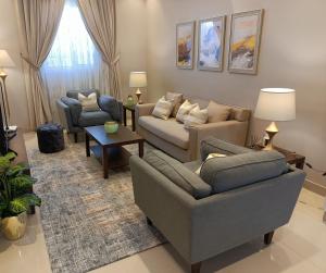 een woonkamer met 2 banken en een tafel bij F residence, Elegant & Luxury in Riyad