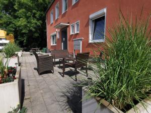 un patio avec des chaises et une table en face d'un bâtiment dans l'établissement Bahnhof City Loft & Apartments, à Augsbourg
