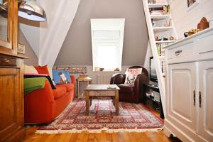 a living room with an orange couch and a staircase at Saint-Malo Apartment in Saint Malo