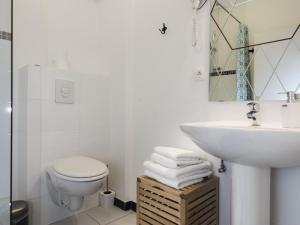 La salle de bains blanche est pourvue d'un lavabo et de toilettes. dans l'établissement Le Gabriel, à Strasbourg