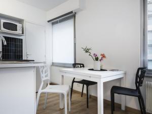 cocina con mesa blanca y sillas en Le Gabriel, en Estrasburgo
