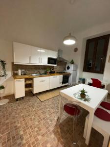 une cuisine avec des placards blancs et une table avec des chaises dans l'établissement Appartamento Stazione Termini, à Rome