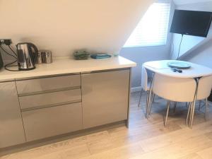 a kitchen with a counter and a table and a stool at The Contemporary Studio in Bracknell