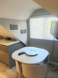 a small kitchen with a table and a tv at The Contemporary Studio in Bracknell