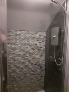 a bathroom with a shower with a tiled wall at The Contemporary Studio in Bracknell