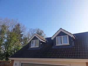 a house with a black roof and two windows at The Contemporary Studio in Bracknell