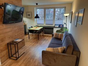 ein Wohnzimmer mit einem Sofa und einem Tisch in der Unterkunft Brzeźno plaża in Danzig