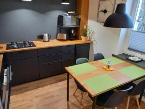 eine Küche mit einem Holztisch sowie einem Tisch und Stühlen in der Unterkunft Brzeźno plaża in Danzig
