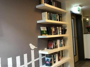 a book shelf filled with books on a wall at Bayrischer Hof in Krefeld