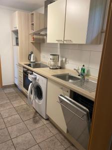 a kitchen with a sink and a washing machine at Traumhaftes Ferienhaus in Husen