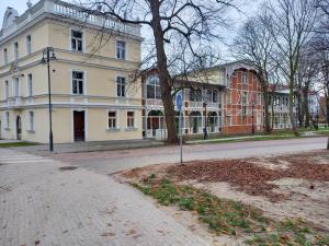 a building on the side of a street with a tree at Brzeźno plaża in Gdańsk