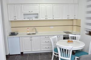 une cuisine avec un évier et une table avec des chaises dans l'établissement Zlatibor Hills Zeus, à Zlatibor