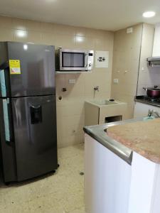 a kitchen with a stainless steel refrigerator and a microwave at Apartamento mar in Cartagena de Indias