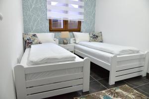 une chambre avec deux lits blancs et une fenêtre dans l'établissement Zlatibor Hills Zeus, à Zlatibor 27 autres photos