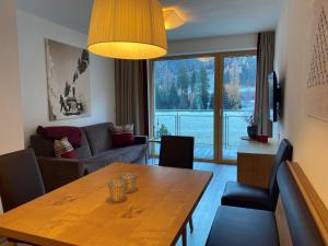 ein Wohnzimmer mit einem Tisch und einem großen Fenster in der Unterkunft Haus Bergleben in Sankt Anton am Arlberg