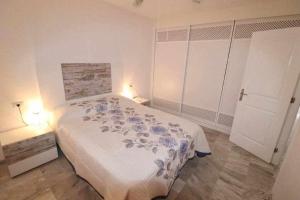 a bedroom with a bed with blue flowers on it at Dinastia B403 by Tenerife Rental and Sales in Los Cristianos