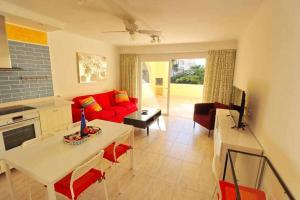 salon z czerwoną kanapą i stołem w obiekcie Mare Verde B12 by Tenerife Rental and Sales w Adeje