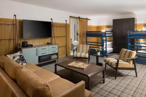 a living room with a couch and a tv at The Virginian Lodge in Jackson