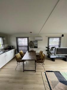 een keuken en een woonkamer met een tafel en stoelen bij De parel van Valkenbosch in Oisterwijk