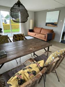 ein Wohnzimmer mit einem Holztisch und einem Sofa in der Unterkunft De parel van Valkenbosch in Oisterwijk