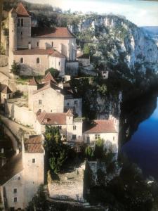 a village on the side of a mountain with water at Le Mas de Laval in Saint-Cirq-Lapopie