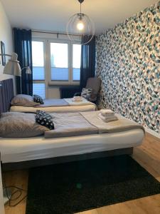 two beds in a room with a large window at Brzeźno plaża in Gdańsk