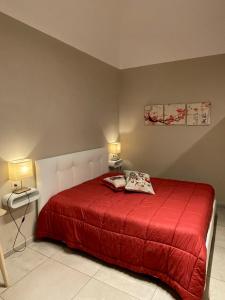una camera con un letto rosso con due cuscini sopra di PortaMedina House a Napoli