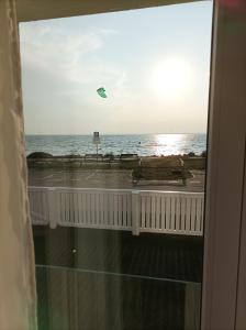 un cerf-volant survolant l'océan depuis un balcon dans l'établissement Kusfeld, à Kuźnica
