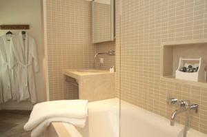 een badkamer met een douche, een wastafel en een bad bij Kasteel Huis Bergh in 's-Heerenberg