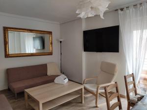 ein Wohnzimmer mit einem Sofa und einem TV in der Unterkunft Mi Piso en Béjar in Béjar