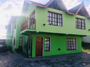 a green house with a building at B&B Nahuel en Ushuaia in Ushuaia