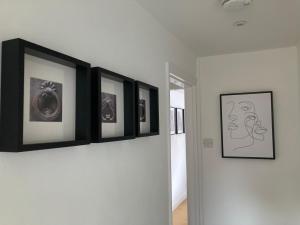 a row of pictures on a wall in a room at Witcroft Cottage in Pershore