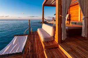 ein Deck eines Bootes mit einem Bett auf dem Wasser in der Unterkunft Presidente InterContinental Cozumel Resort & Spa, an IHG Hotel in Cozumel