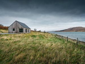 a house on a hill next to a body of water at Beautiful views from right above the water in Dunan