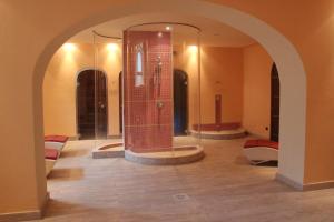 a room with a shower in a room with an arch at GH Palazzo Suite & SPA in Livorno