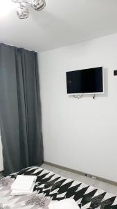 a bedroom with a bed with a tv on the wall at Apartament Ella ,wifi inclus la Straja ,Lupeni ! in Lupeni
