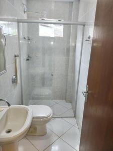 a bathroom with a shower and a toilet and a sink at Gênesis Beach Hostel! Quartos compartilhados e privativos na Pinheira in Palhoça