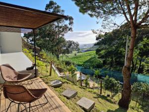 a patio with chairs and a view of a vineyard at Place of Moments Natur-Suites SPA in Vila Franca do Campo