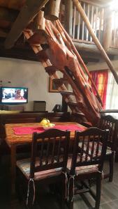 een eetkamer met een tafel en een houten trap bij Cabañas La Polaca 2 in Santa Clara del Mar