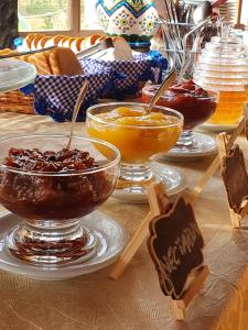 a table topped with bowls of food with spoons at Pousada do Morro Verde in Carvalhos