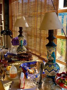 einen Tisch mit zwei Vasen auf einem Tisch mit Essen in der Unterkunft Pousada do Morro Verde in Carvalhos