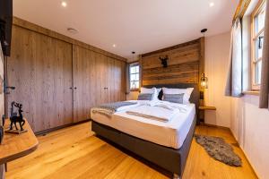 a bedroom with a large bed and wooden walls at Alm-Chalets-Samerberg in Samerberg